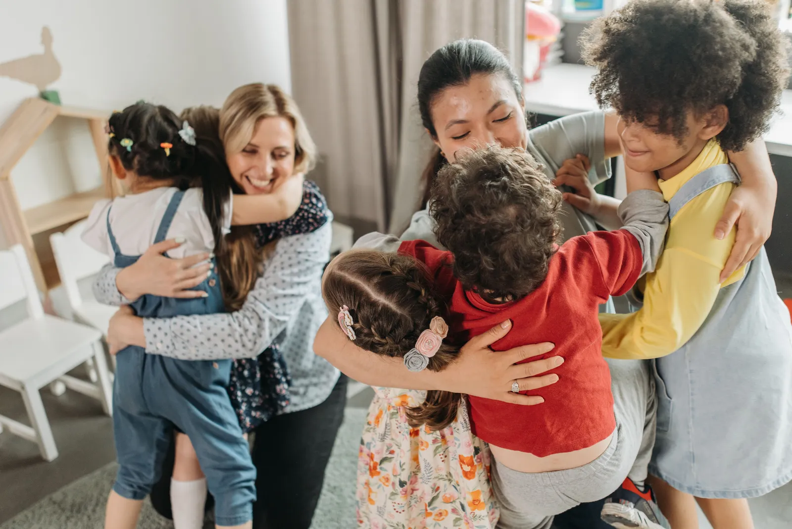A carer embracing a group of young children