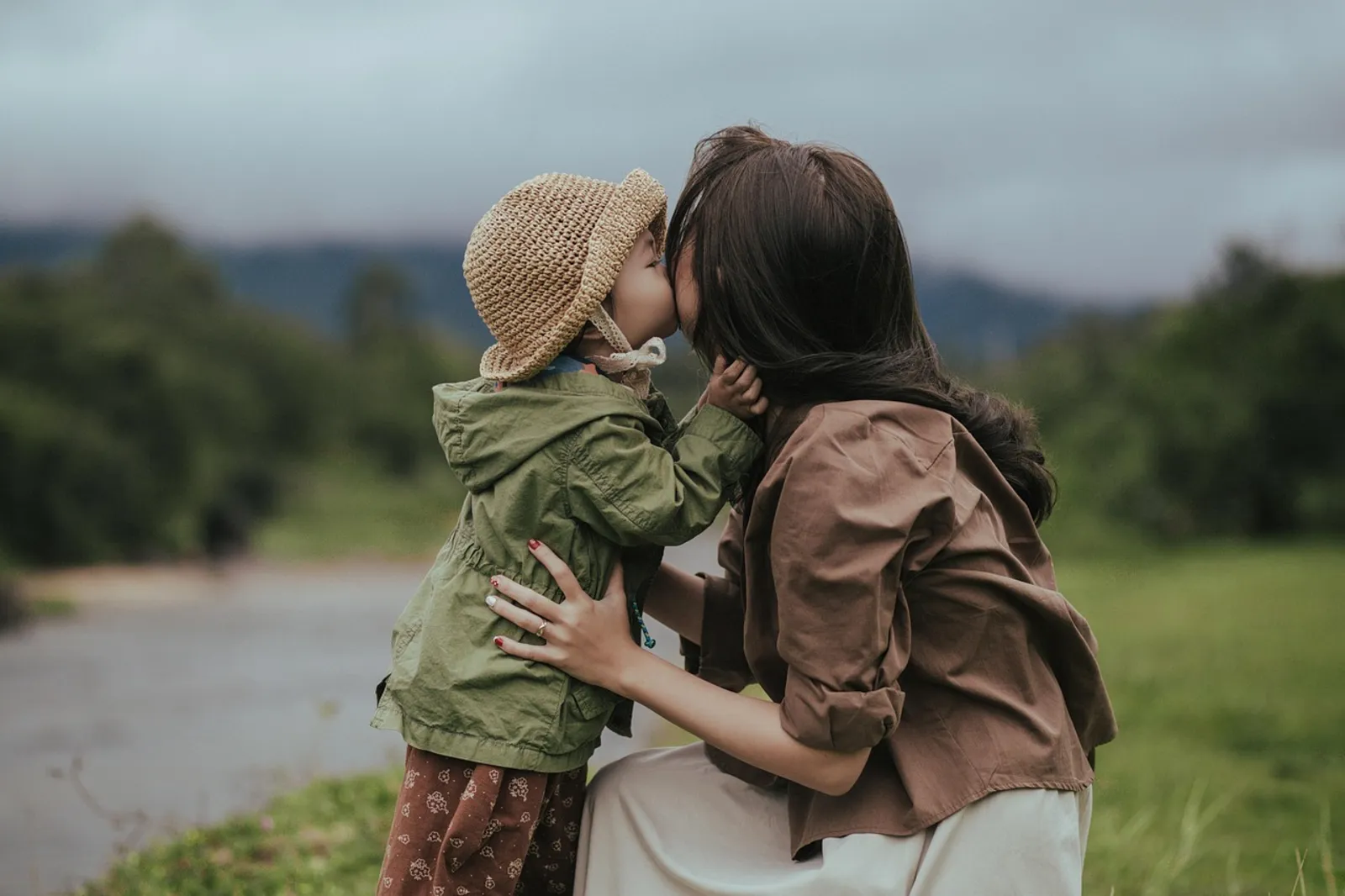 A parent holding a child close outdoors